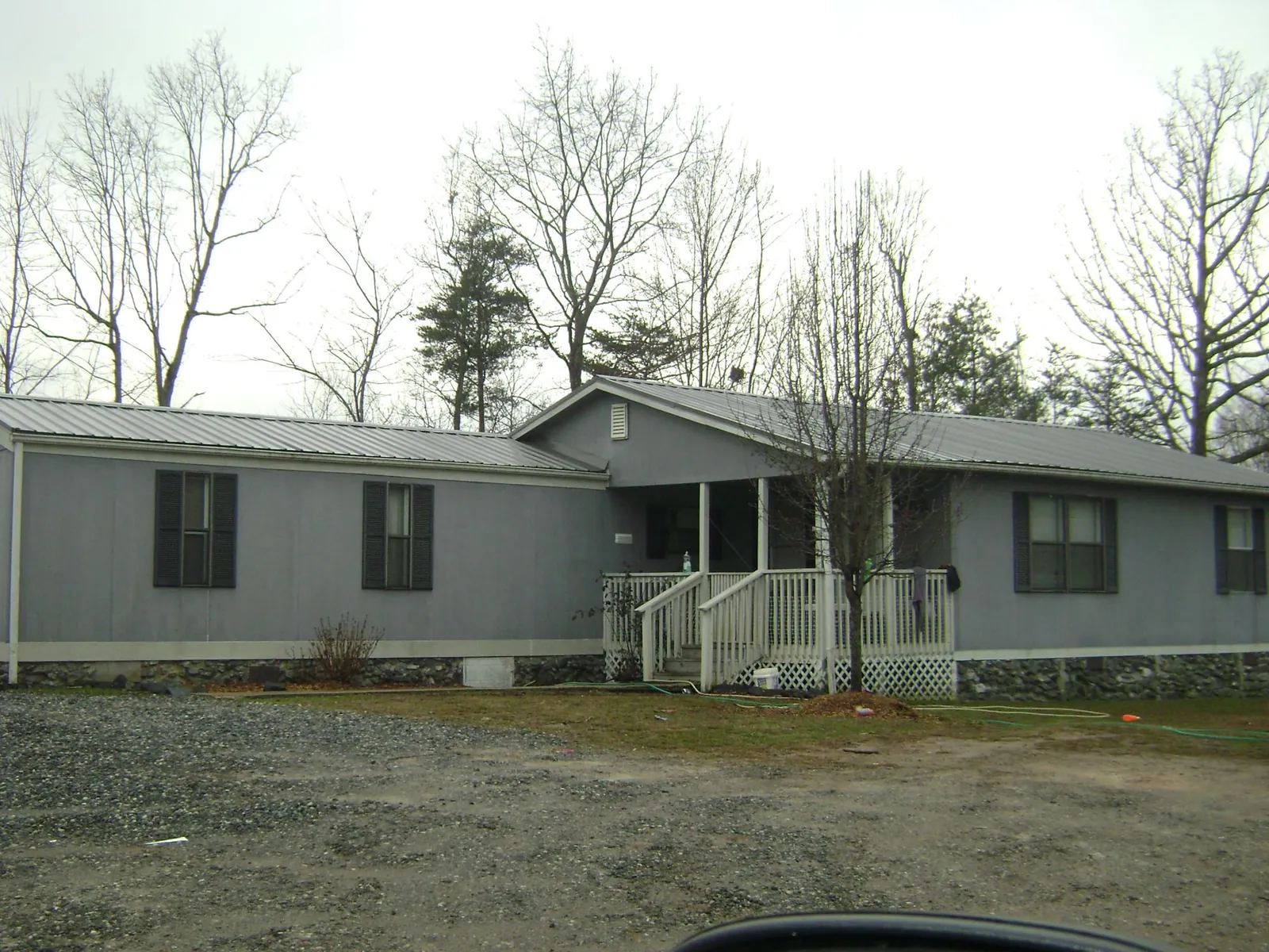 Metal roof over a manufactured home with a covered front porch in Mc Dermott